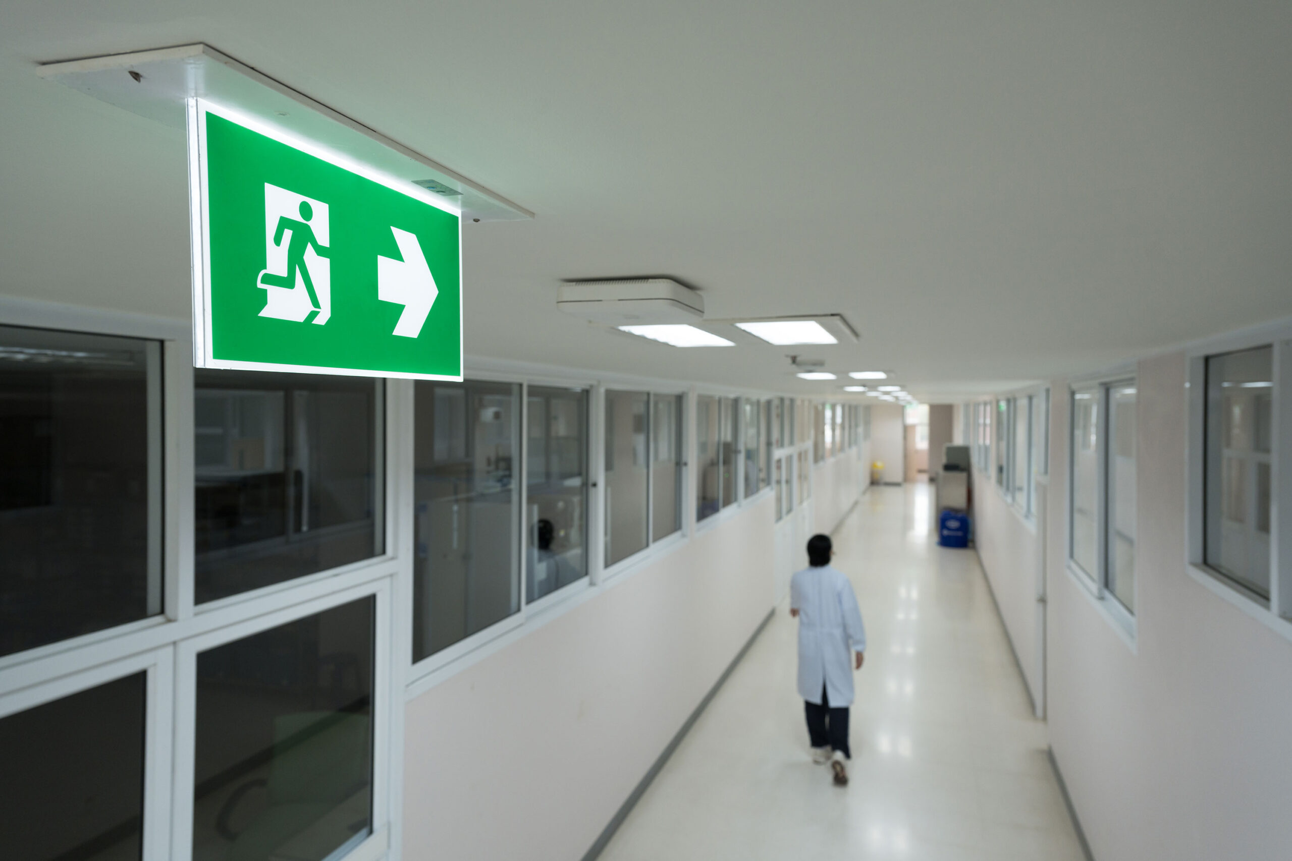 fire exit sign on white ceiling at hospital